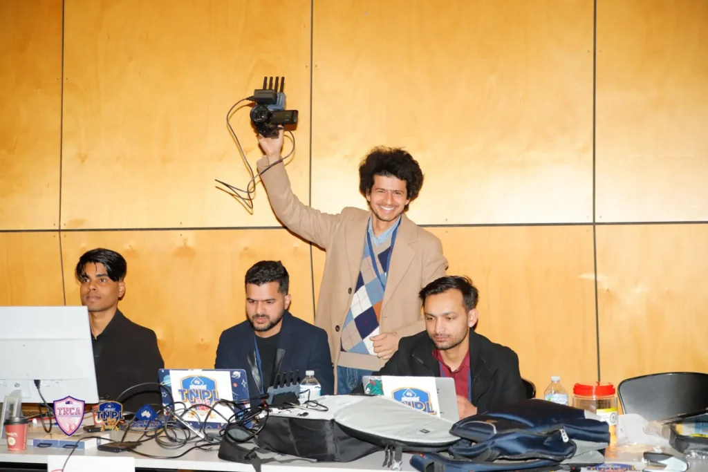 Crew member holding a camera rig up high above the production desk