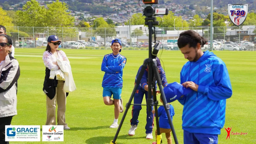 Crew member setting up a camera on the field as players warm up