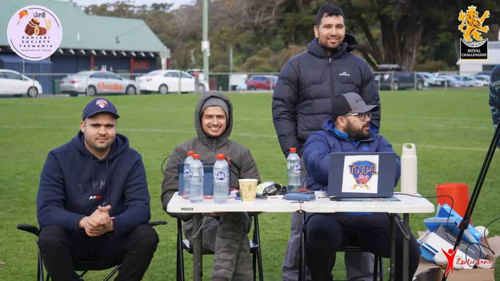 Crew seated at a desk with a laptop on the field