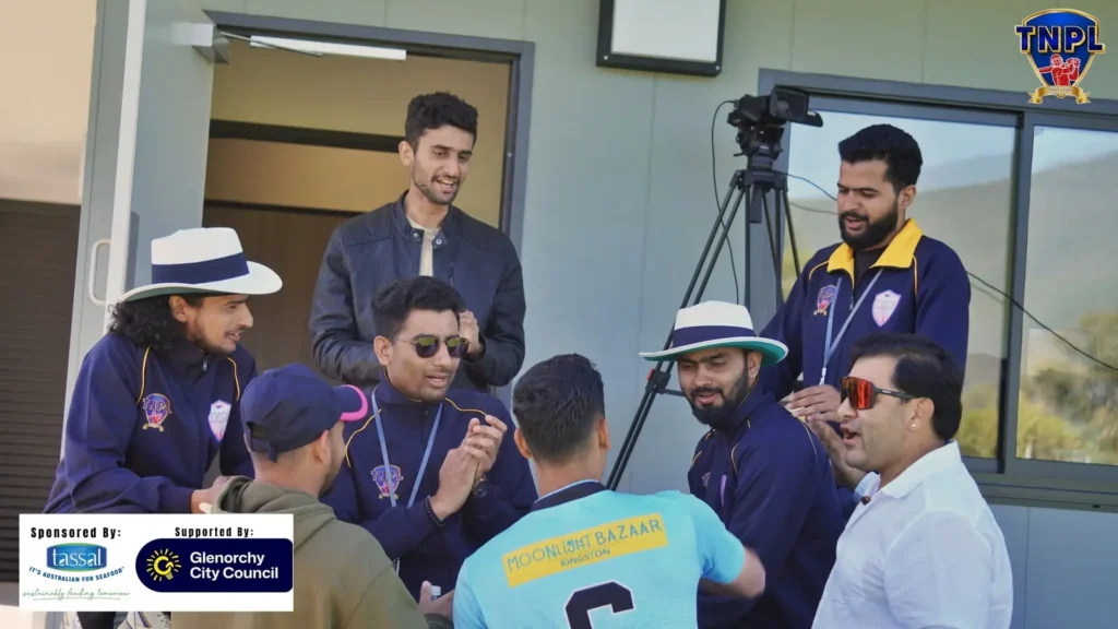 Crew next to a camera on a tripod, chatting with players and officials