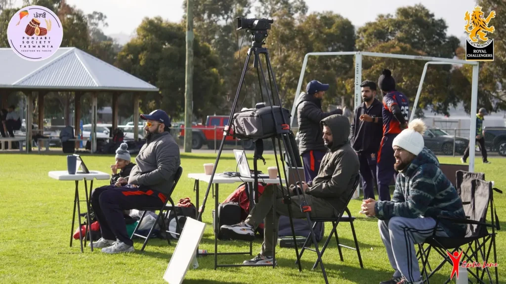 Crew in beanies and jackets at their gear tables on a cold day at the ground